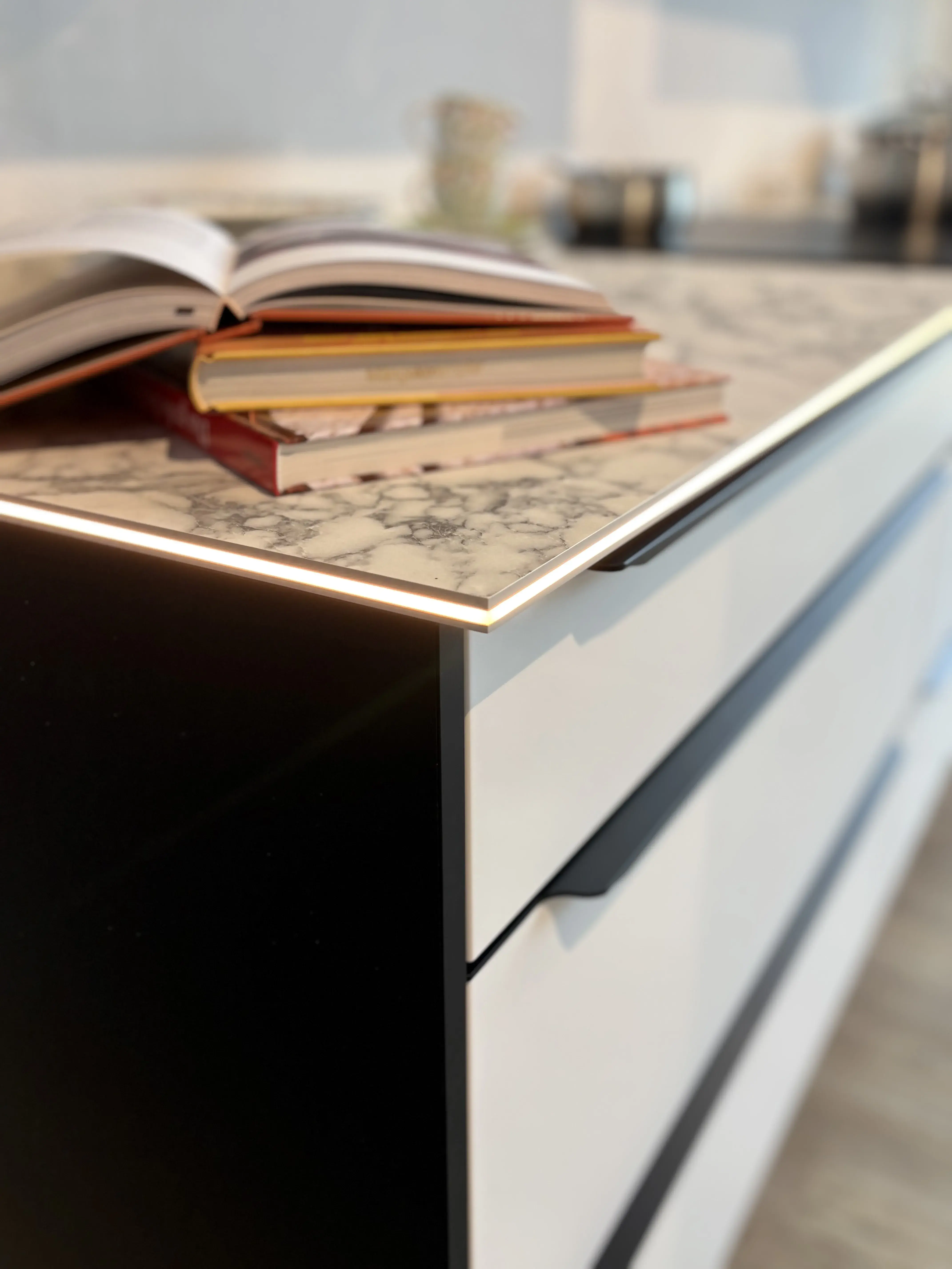 Mehrere Bücher liegen auf einer modernen Küchenarbeitsplatte.